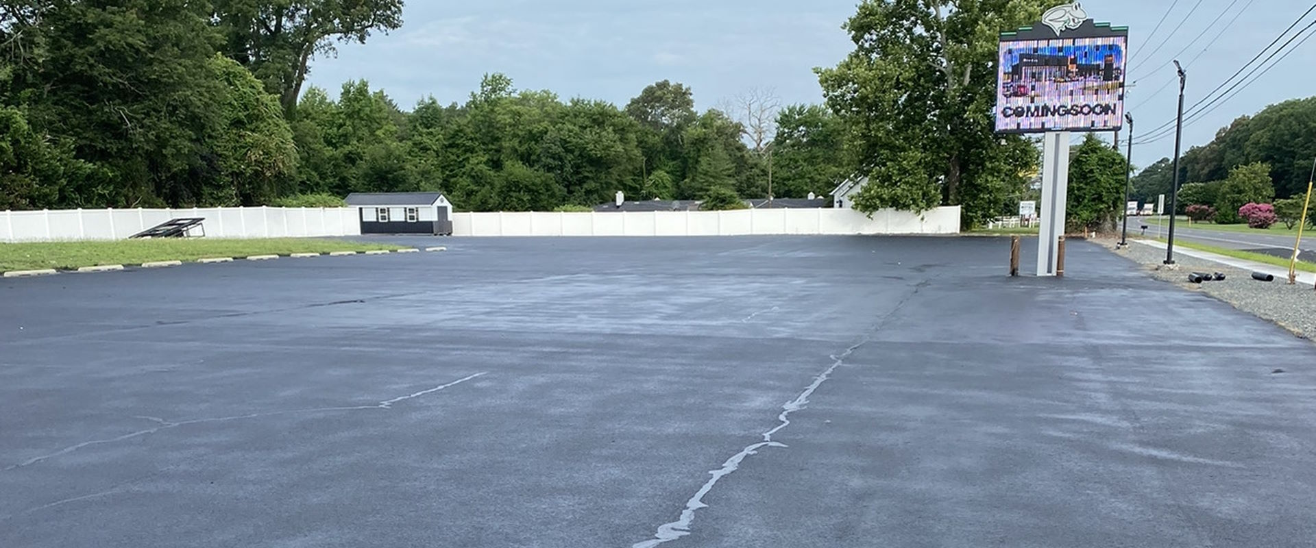 Horizontal photo of an asphalt driveway that has been professionally sealcoated